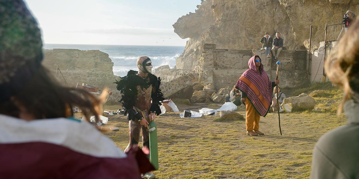 Production still from Tremble Staves with performers in costume and makeup on a beach setting