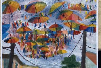 A painting of colorful umbrellas suspended above a street scene.