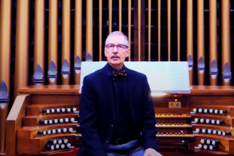 Lecturer Gregory Eaton in front of an organ