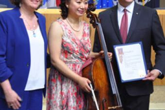 Hai Zheng with her cello and accompanied by Austin Mayor Steve Adler and city council member 