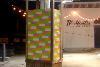 An art resembling a colorful Jenga game sits on a patio