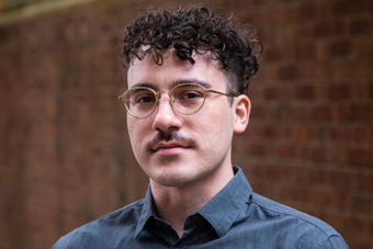 Roberto Di Donato is named the new Producing Director of the Tantrum Theater, and is pictured here looking into the camera against a brick wall.