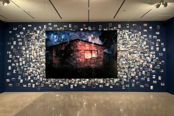 Large wall display of photography collage with a single large photograph of a home in the center