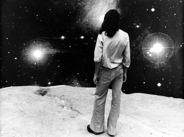 black and white image of man looking at stars
