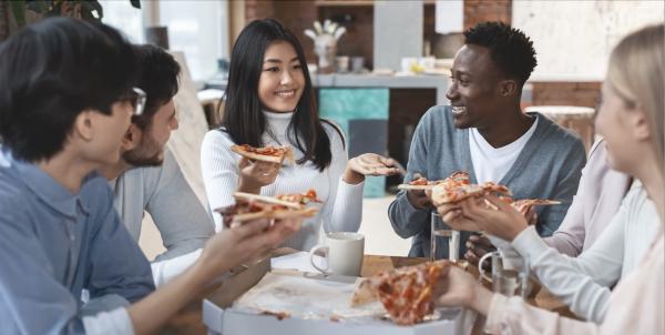 Students chat while eating pizza