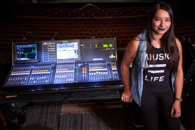 Malyssa Quiles stands next to an audio board