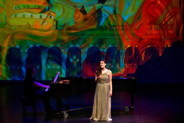 Mezzo soprano Talin Nalbandian singing in front of a watercolor background.