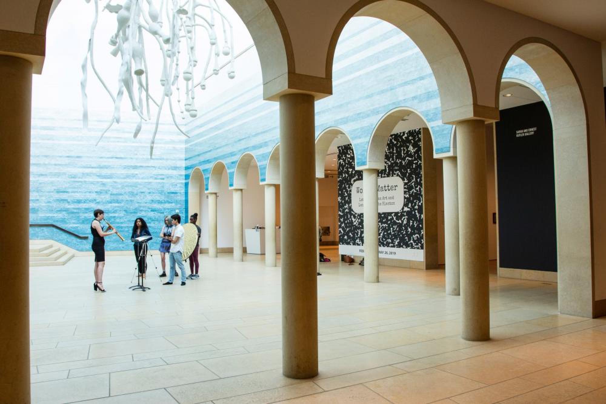 A crew films a saxophonist in the Blanton Museum of Art lobby. 