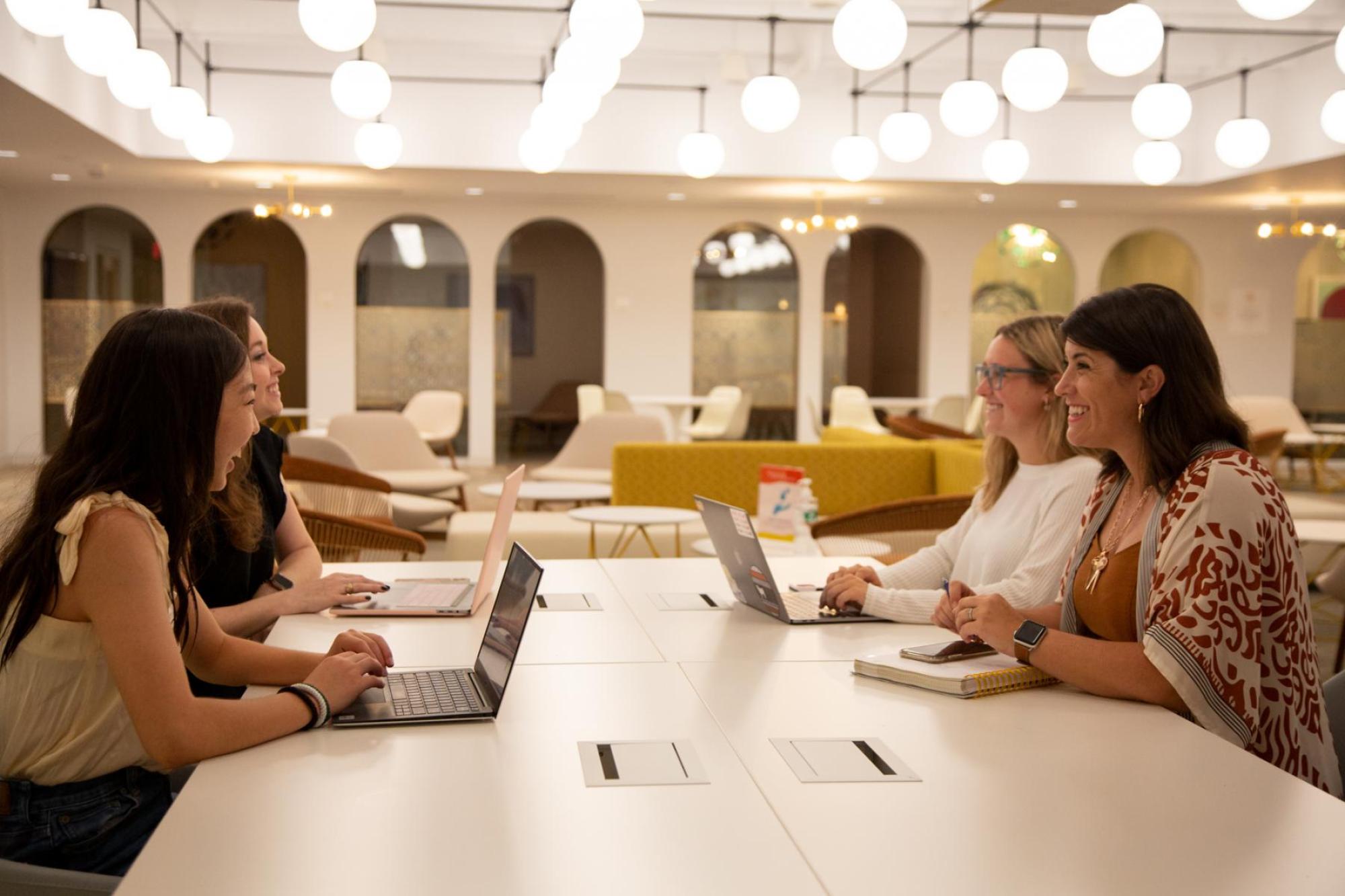 S WEL Institute student interns, from left, Anna Esaka (special projects associate); Catherine Scoggins (events manager) and Ainslee Harrison (events coordinator) meet with Director Lesley Robinson, right, in the new Kendra Scott Center. Photo by Alicia Dietrich