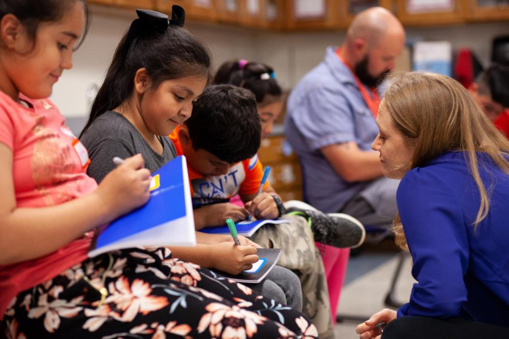 middle school students writing in notebooks