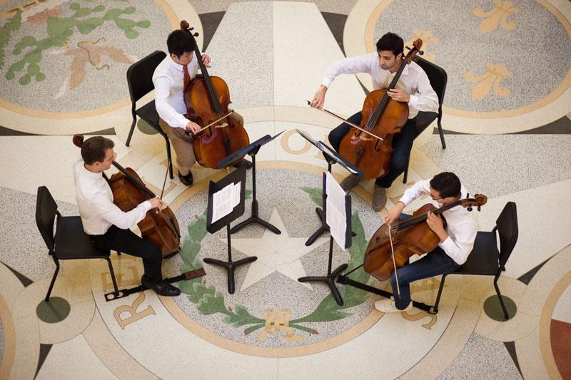 Four men play string instruments