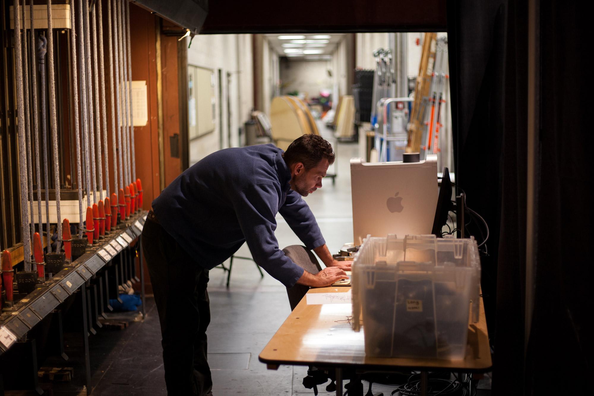 J.E. Johnson working at a computer backstage