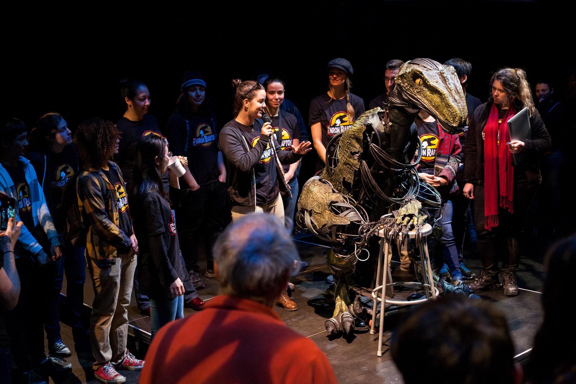 Students wearing Enron raptor tshirts at an unveiling with an animatronic raptor