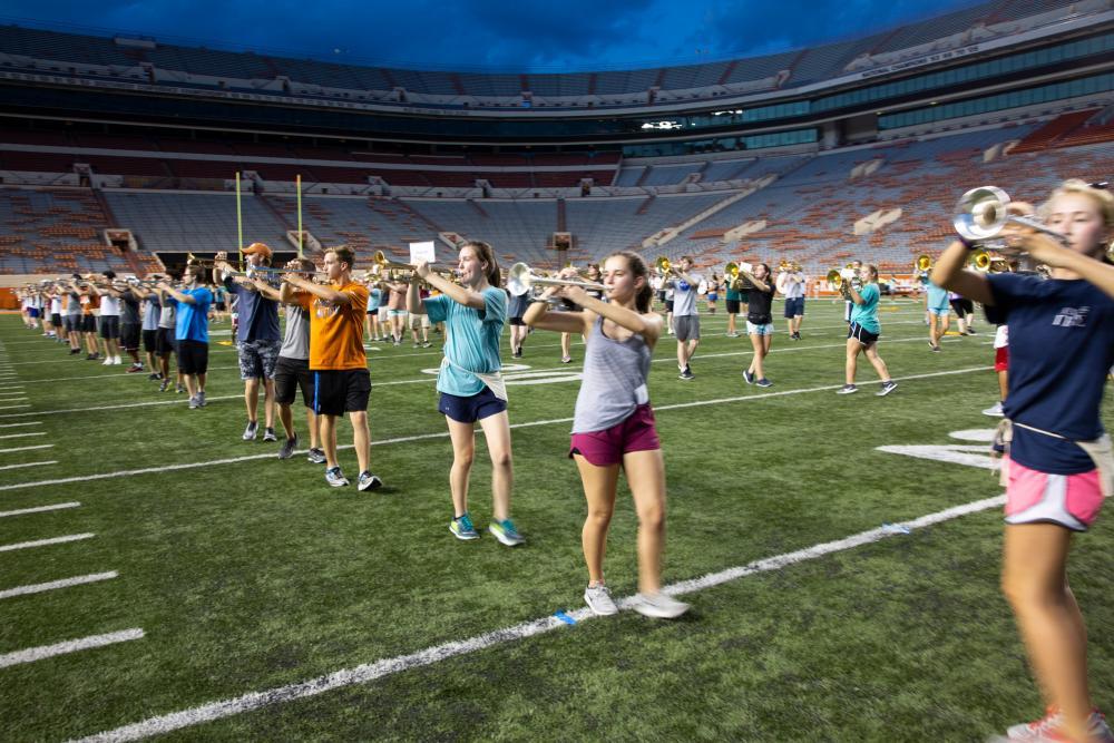 Longhorn marching band rehearsing on a football field 