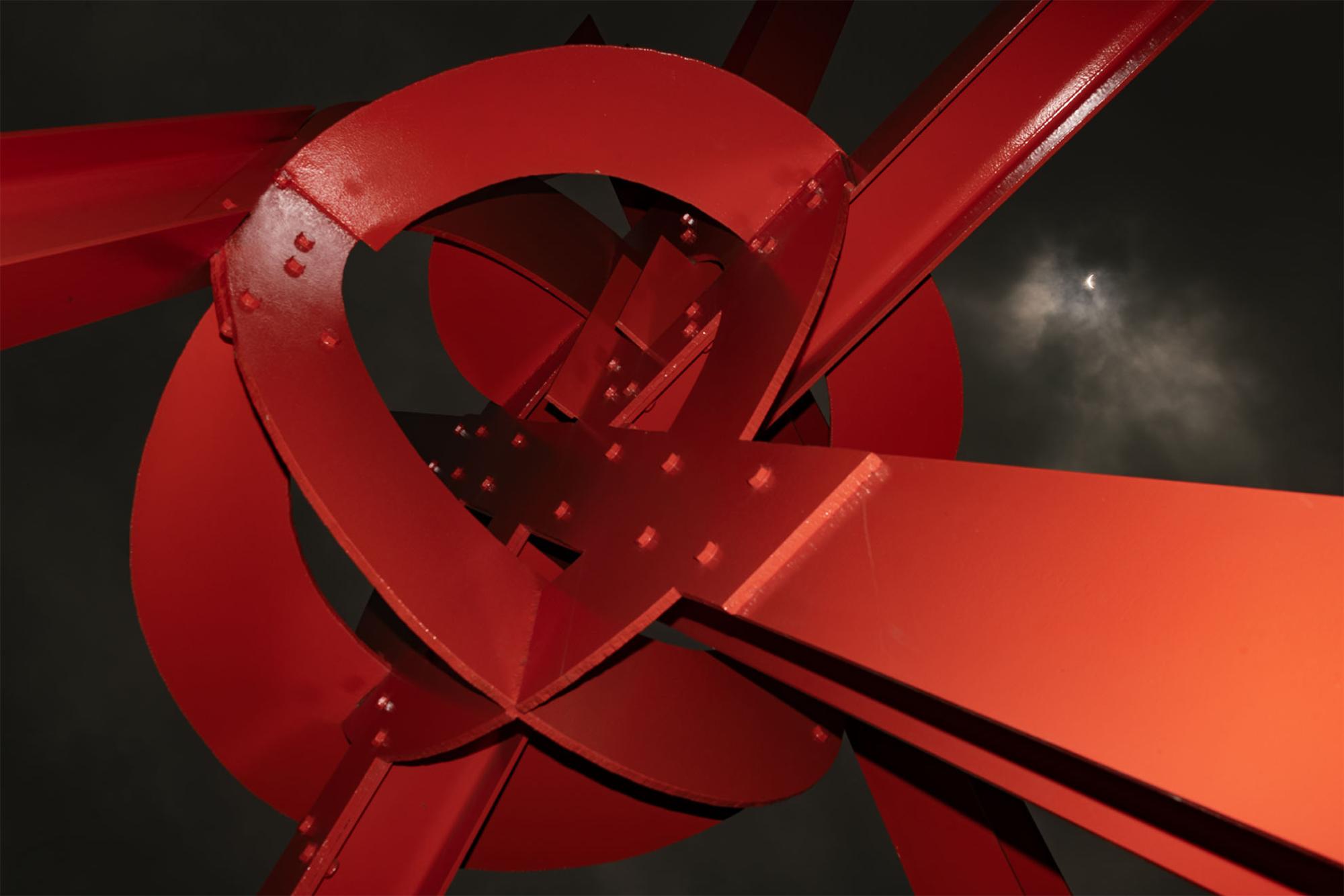 The total solar eclipse is visible above the Clock Knot sculpture by Mark di Suvero