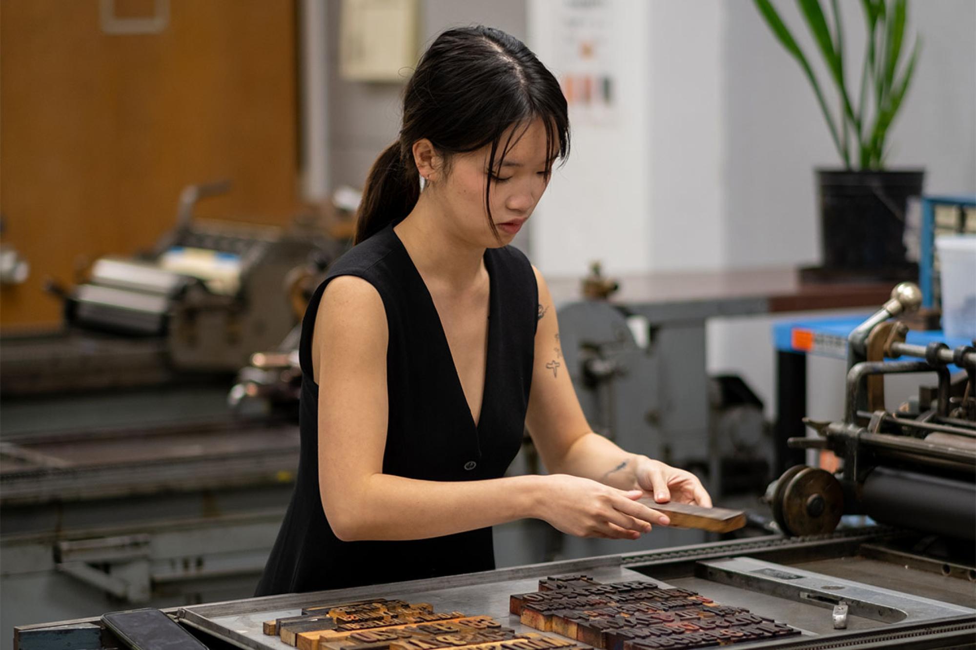 A student handles type from the Rob Roy Kelly Wood Type Collection