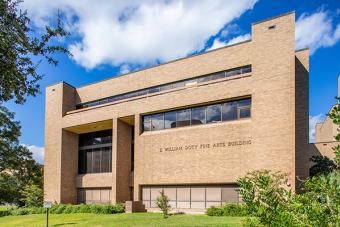 An exterior shot of a brick building on a sunny day with the name "E. William Doty Fine Arts Building" on the brick.