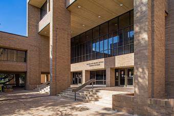 A large brick building with brick columns and glass windows, with "Sarah and Ernest Butler School of Music" on the front.