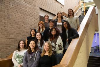 Members of Fine Arts Council pose for a photo on a staircase in the Fine Arts Library