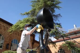 A member of Landmarks Preservation Guild cleans Simone Leigh's sculpture in the Anna Hiss courtyard.