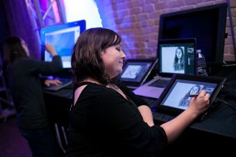 A student draws on a tablet at the launch exhibition for the Center for Arts and Entertainment Technologies. Photo by Lawrence Peart.