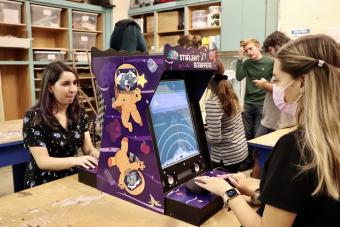 Students play a tabletop arcade game