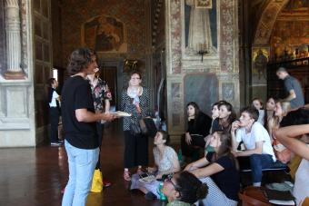 Ann Johns, far left, listens to Nick Purgett, an Art History sophomore, present at the Sala del Mappamondo in the Palazzo Pubblico in Siena.