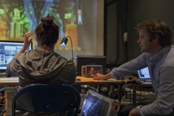 Kate Ducy and Sven Ortel work on projection design for President Fenves' inauguration. Photo by Michael Arbore.