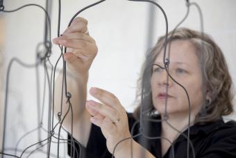 Artist Beth Campbell adjusts an installation 
