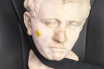 A marble bust on a car seat with a Goodwill price tag