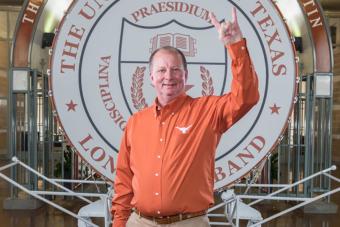 Rick Church gives a hook'em hand sign in front of the Big Bertha drum