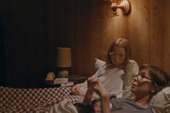 A scene from JANET PLANET in which a mother and daughter sit next to each other in a bed