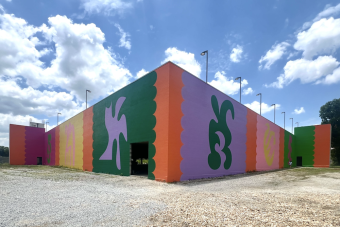 Carlos Rosales-Silva's public mural on the parking garage of The Momentary in Bentonville, Arkansas uses bright colors with figures in opposite color configurations.