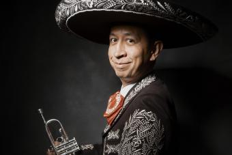 Director of Texas’ Mariachi Paredes and Assistant Professor of Practice Greg Cavazos in a portrait with his trumpet and mariachi uniform