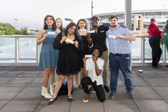 A group of students show their tickets at a Broadway performance at Texas Performing Arts