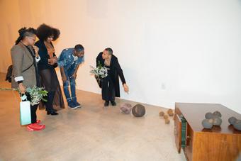Attendees discussing and admiring a collection from the Las Nietas de Nonó exhibition