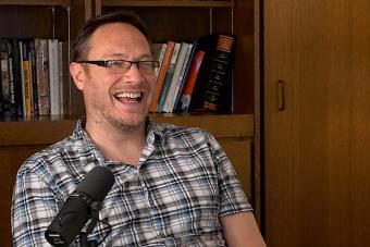 Andrew Parker laughing in front of a bookcase