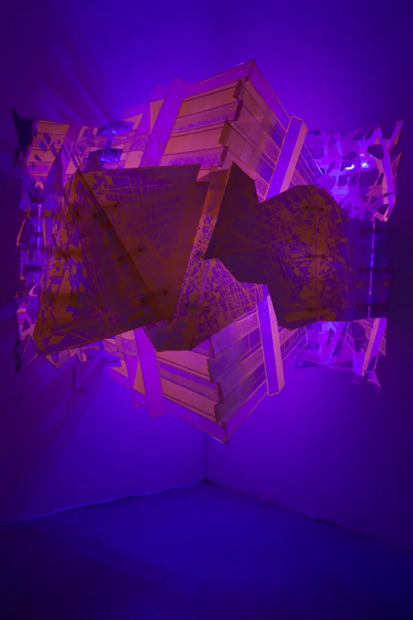 pink and purple geometrics shapes formed by light and prints attached to wall