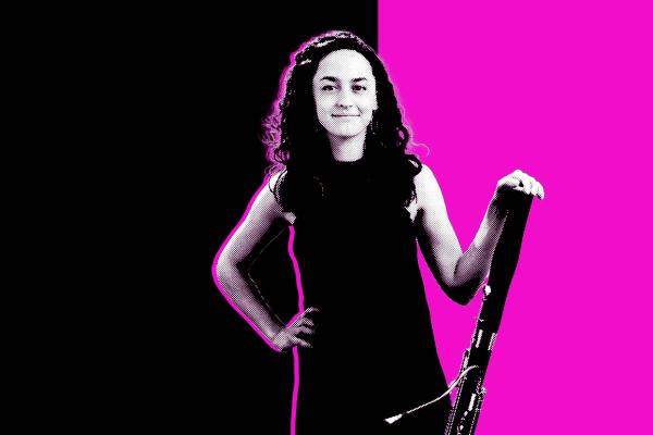Black and white photo of a student holding her bassoon in front of a black and magenta background.