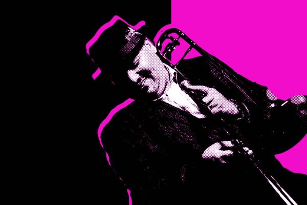 Black and white photo of Michael Dease wearing a hat and holding his trombone in front of a magenta and black background.