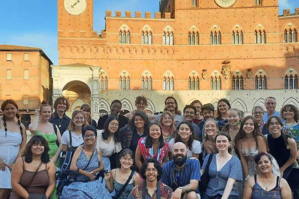 A group of students studying abroad in a piazza in Sienna