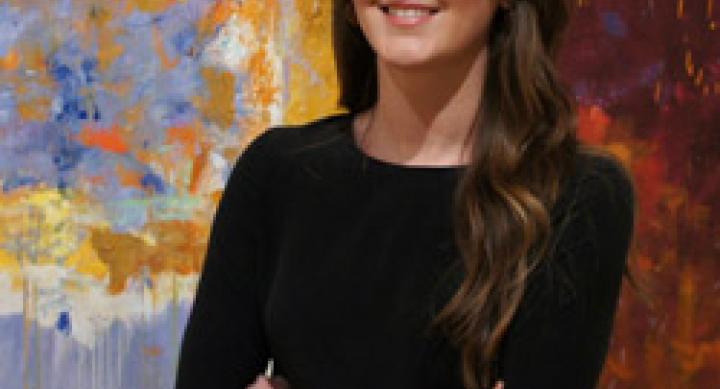 Callan Steinmann in front of an abstract art painting
