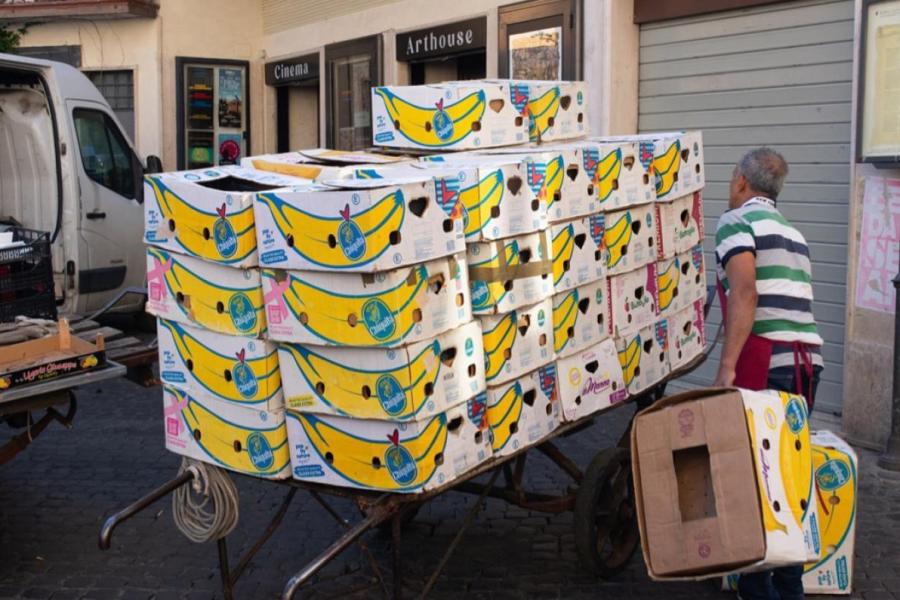 person stacking large box printed with yellow banana graphic