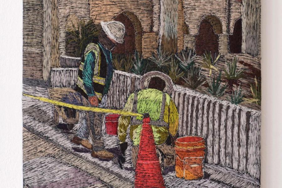 embroidered artwork that portrays utility workers at a manhole in street