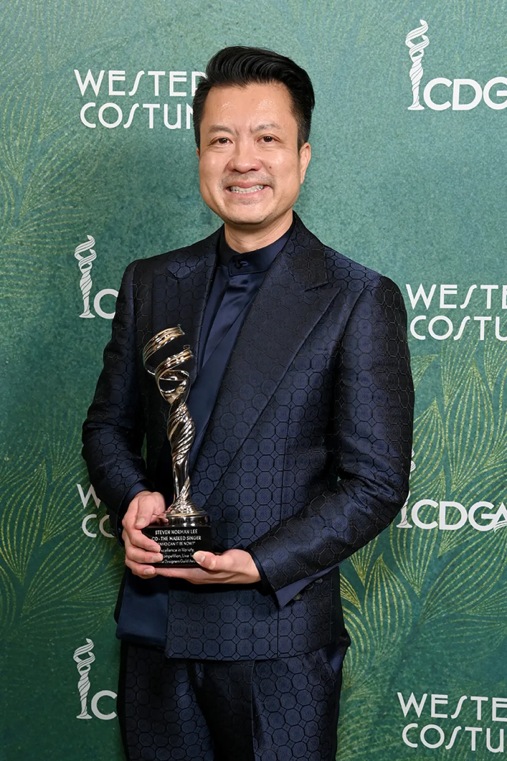Steven Norman Lee holds his Costume Designers Guild Award in the category of Costume Design for Variety, Reality and TV Specials for his work on The Masked Singer.