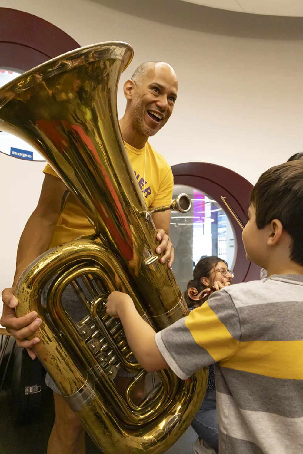 Charles Carson holds a tuba for a child to play