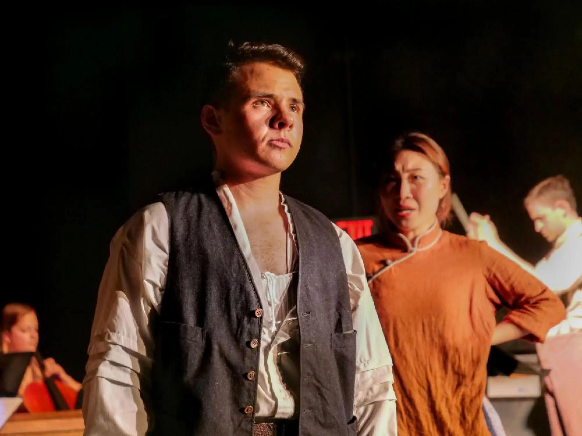 The Barmaid (Chang Liu) sings to Charley (Holden Madagame). Composer Keith Allegretti conducts. Photo by Logan Smith.