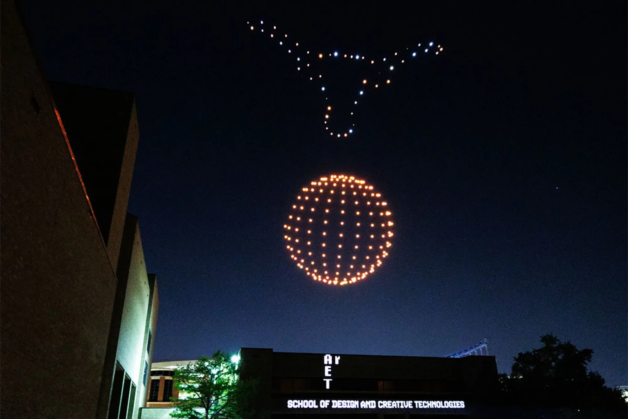A student-created drone show with a formation a 3-D Longhorn over an orange sphere