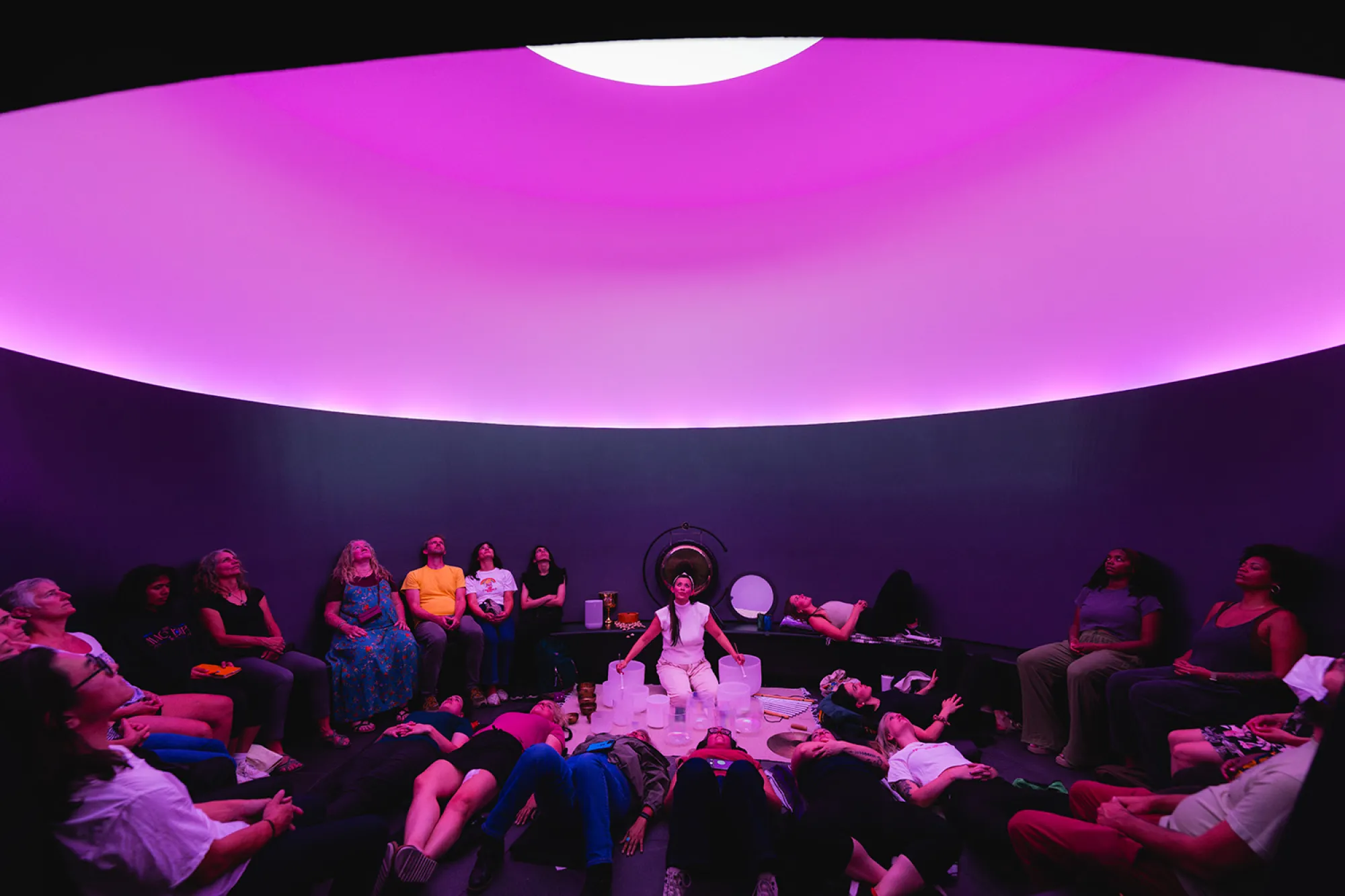 A musician plays music on the floor of James Turrell's Skyspace The Color Inside at The University of Texas at Austin.