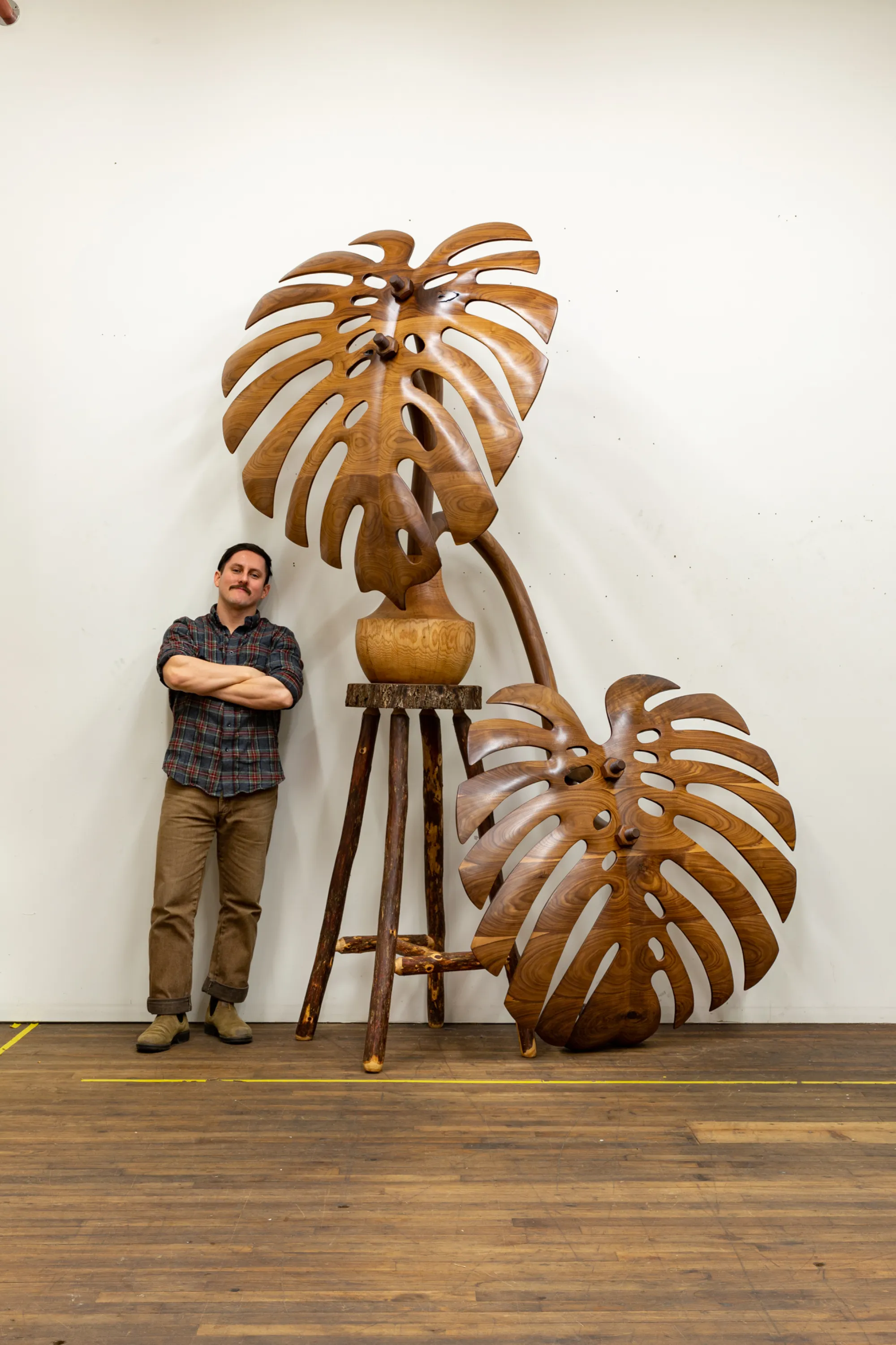 Raul De Lara with wooden botanical sculpture